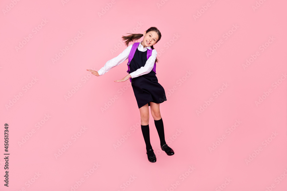 Full length body size photo schoolgirl jumping showing size isolated pastel pink color background