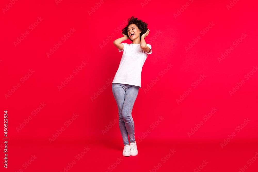 Full length body size photo smiling curly woman touching silky hair after salon isolated bright red color background