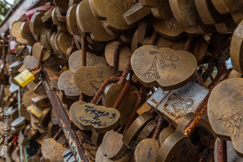 Obraz na plátně Many padlocks in the shape of a heart glued to the gate as a symbol of the love