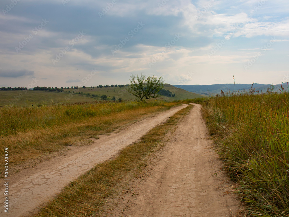 A country road in the steppe on the hills.