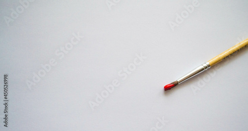 brush with red paint on a white background