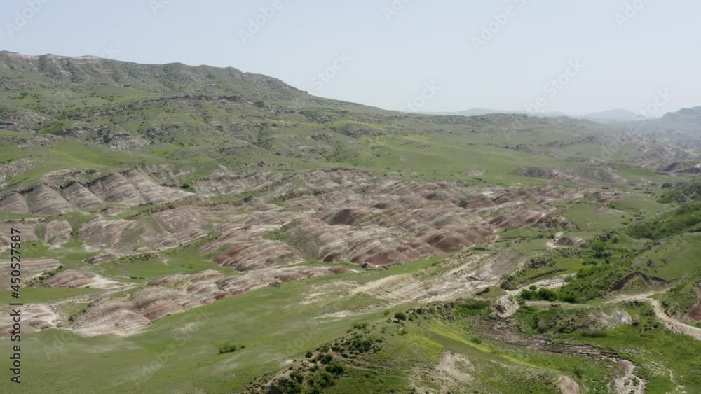Aerial view over colorful landscape of mineral stone rock formation mountains. Bright summer day. Clear blue sky. Forward movement, pan to left. 4k footage. Aerial view over colorful landscape of mineral stone rock formation mountains. Bright summer day. Clear blue sky. Forward movement, pan to left. 4k footage.