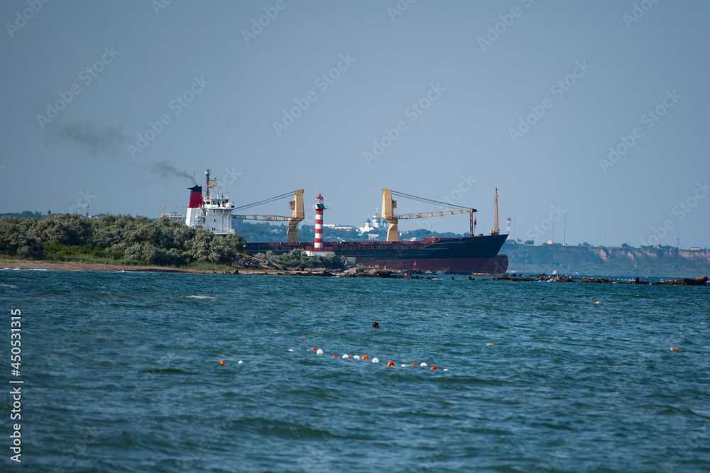 A cargo ship enters the sea from the port.