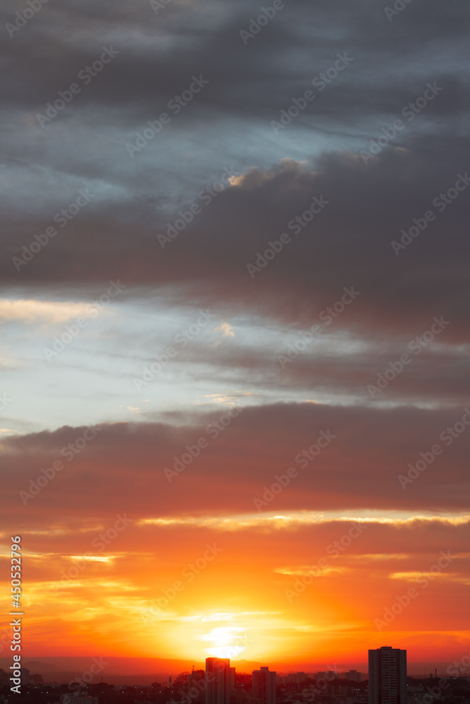 Sunrise skyline with red color fire on a cloudy winter day on a city. Space for text.