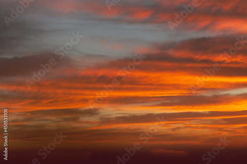 Sunrise sky with red color fire on a cloudy winter day. Space for text. © Andre Nery