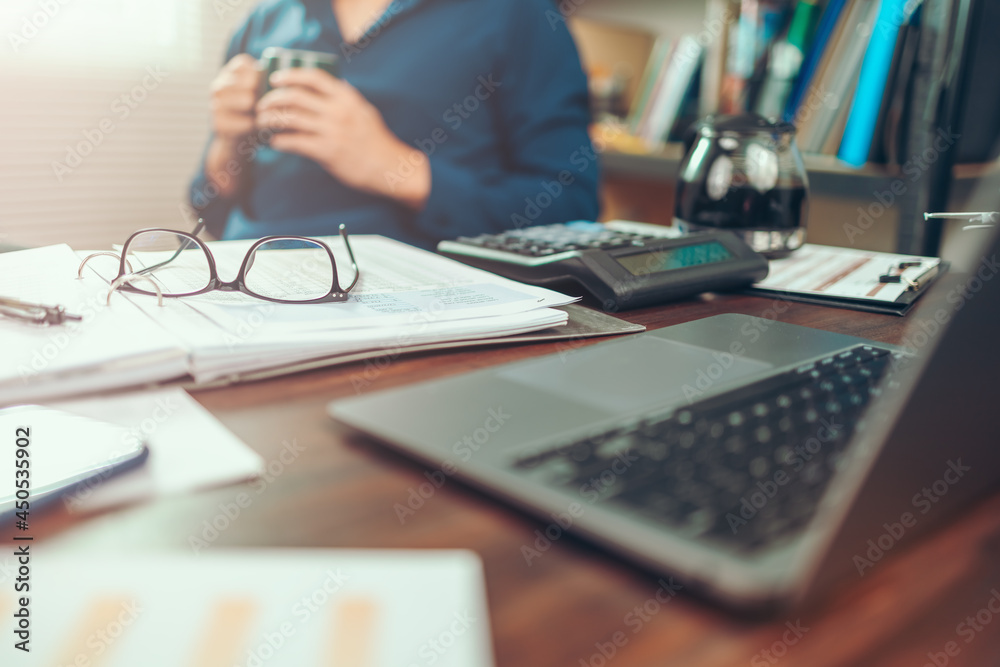 Glasses on data sheet in the office desk. Calculator with accounting report and financial statement on desk. Glasses on data sheet in the office desk. Calculator with accounting report and financial statement on desk.