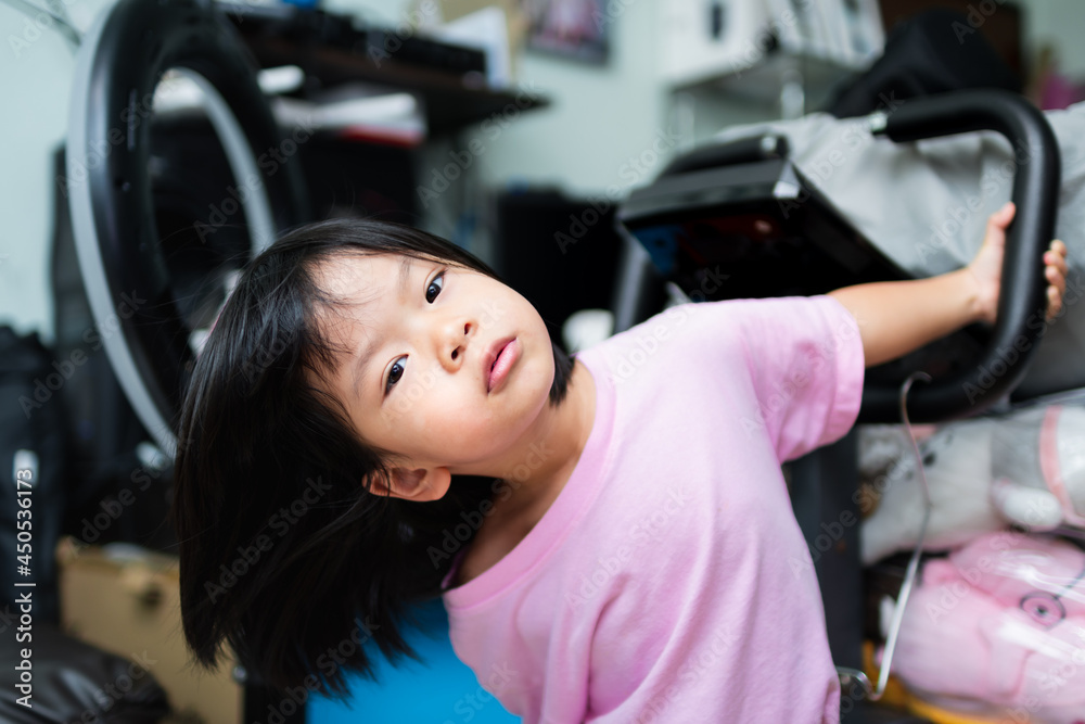 Cute Asian girl hanging on exercise blender bar in the house. Equipment in the home and the safety of young children. Cute Asian girl hanging on exercise blender bar in the house. Equipment in the home and the safety of young children.