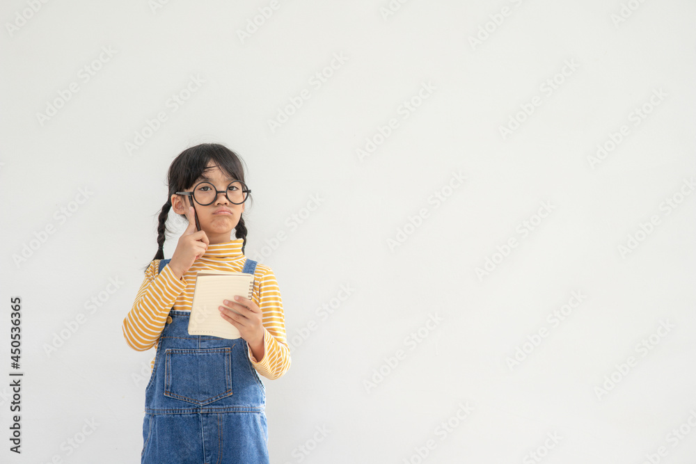 Back to school. A funny little girl in glasses on white background. Child from elementary school with a book. Education Back to school. A funny little girl in glasses on white background. Child from elementary school with a book. Education