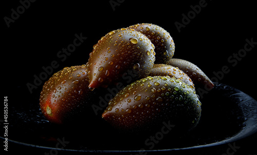 Beautiful ripe cumato tomatoes on a black plate. Cumato tomatoes. photo