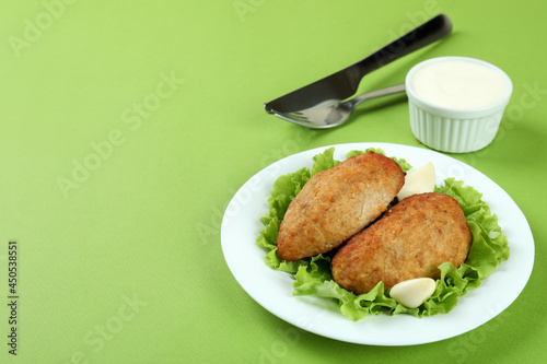 Concept of tasty food with cutlets on green background