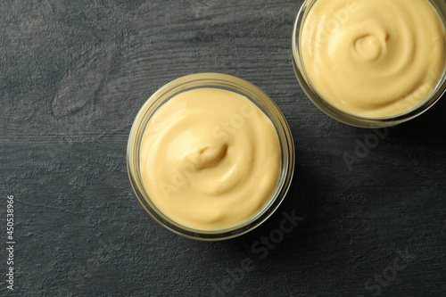 Bowls with cheese sauce on dark background