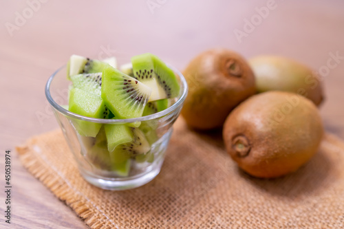 Kiwi fruit in glass on wooden table decorated with sacks