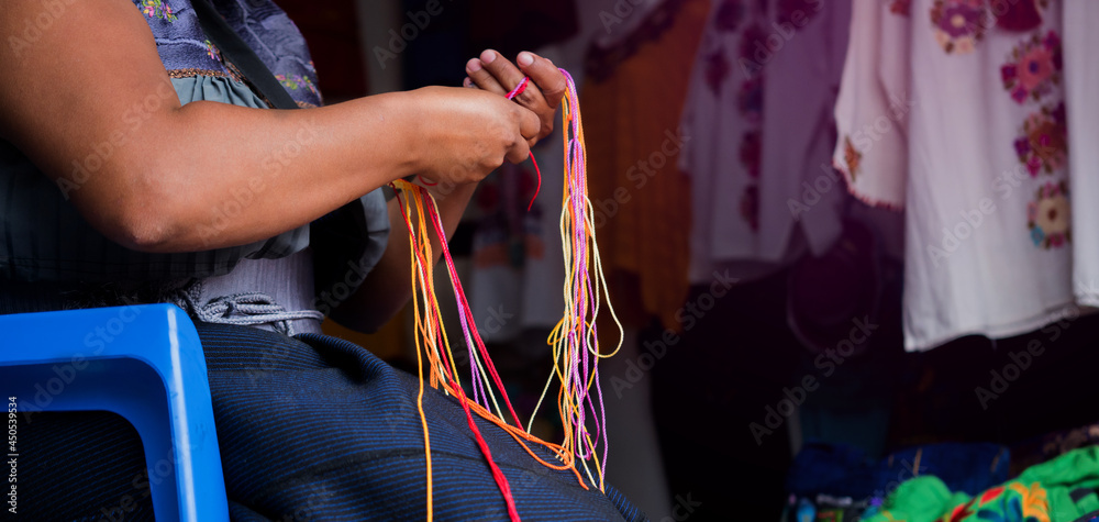 Craftswoman hand weaving blouses, woman's hands knitting by hand, with colorful threads