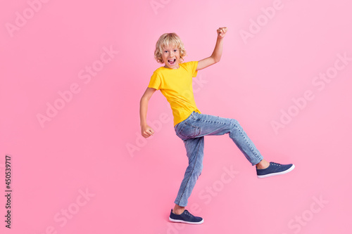 Full body profile side photo of young cheerful small boy happy positive smile go have fun isolated over pink color background