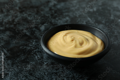 Bowl with cheese sauce on black smokey background
