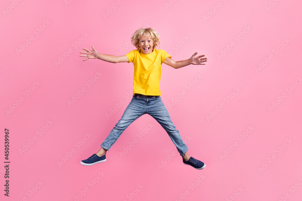 Full length photo of young boy happy positive smile jump open hands hug friendly isolated over pink color background