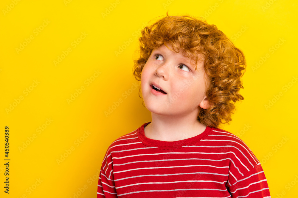 Photo of impressed little boy look empty space wear red shirt isolated on yellow color background Photo of impressed little boy look empty space wear red shirt isolated on yellow color background