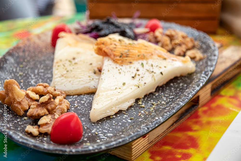 Grilled cheese on a black plate up. Traditional tapas on Tenerife. Canary Islands, Spain. Selective focus Grilled cheese on a black plate up. Traditional tapas on Tenerife. Canary Islands, Spain. Selective focus