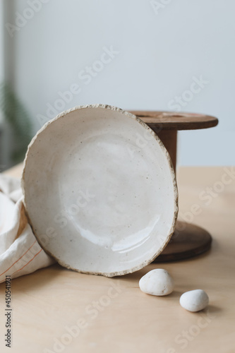 Ceramic bowl on a wooden table top view. Handmade ceramic tableware and pottery
