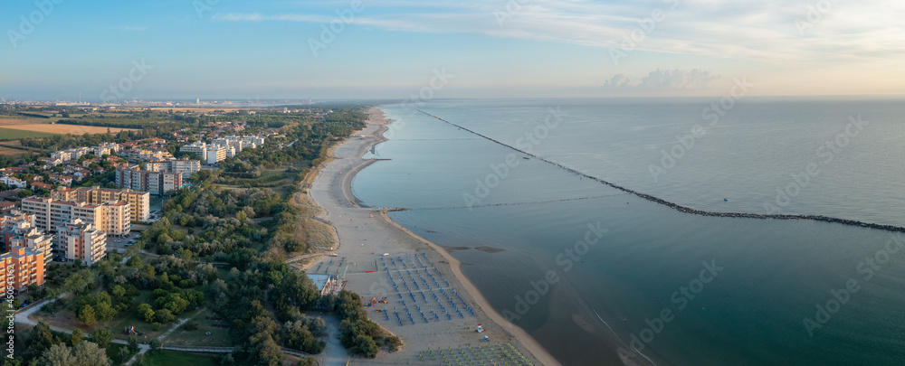 Aerial view of sandy beach with umbrellas and gazebos.Summer vacation concept.Lido Adriano town,Adriatic coast, Emilia Romagna,Italy.