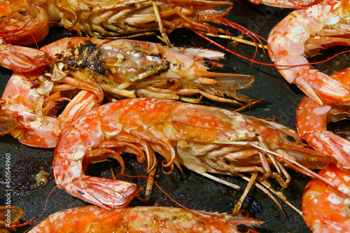 Cocinando deliciosas gambas a la plancha con aceite de oliva. Primer plano de los deliciosos mariscos durante el proceso de cocción.