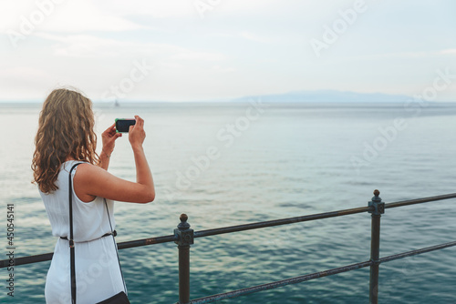 Wallpaper Mural woman taking picture of the sea on the phone Torontodigital.ca