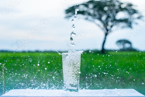 Pour water into a glass placed on a wooden stick. splashing water