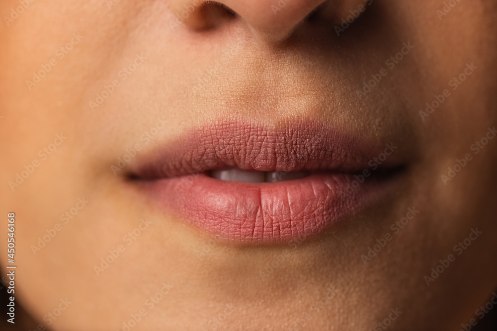 Close-up female lips with nude makeup. Concept of natural beauty, cosmetics, anti age treatment, wellness Close-up female lips with nude makeup. Concept of natural beauty, cosmetics, anti age treatment, wellness