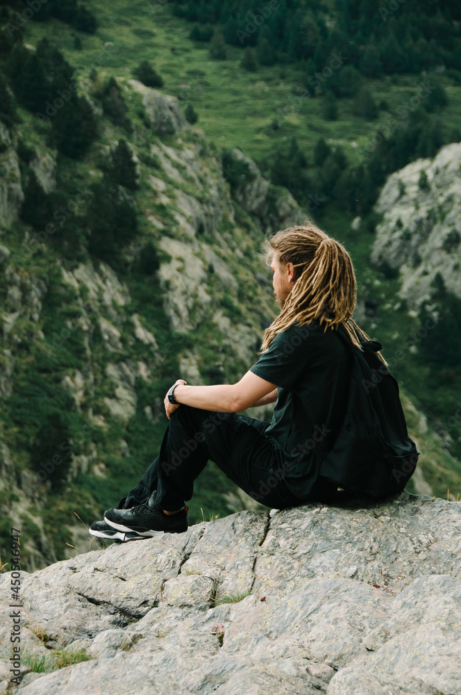 Naklejka premium rasta man sitting on rock