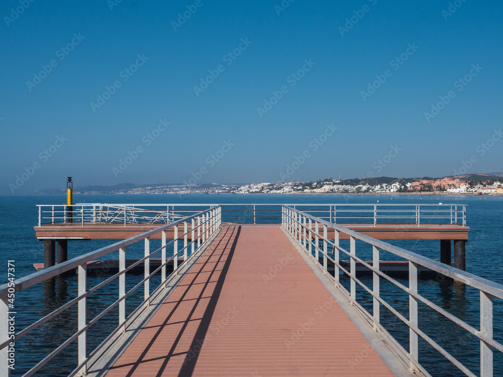 Scene of a lonely dock overlooking the Mediterranean Sea and with a clear sky in Estepona, costa del sol Spain. Scene of a lonely dock overlooking the Mediterranean Sea and with a clear sky in Estepona, costa del sol Spain.