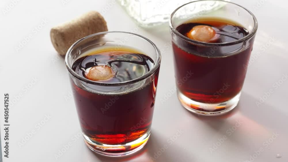 Alcohol beverage in glass with ice. Glass with Wiskey, liquor, brandy. Top viewVideo 4k resolution Alcohol beverage in glass with ice. Glass with Wiskey, liquor, brandy. Top viewVideo 4k resolution