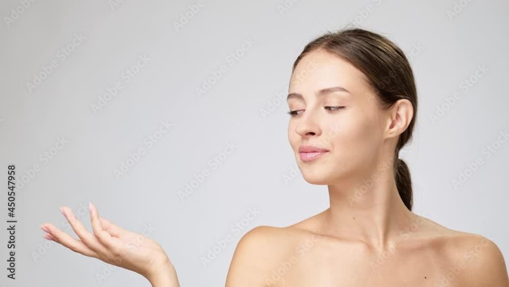 Beautiful Young Woman with Clean Fresh Skin standing over light grey background Beautiful Young Woman with Clean Fresh Skin standing over light grey background