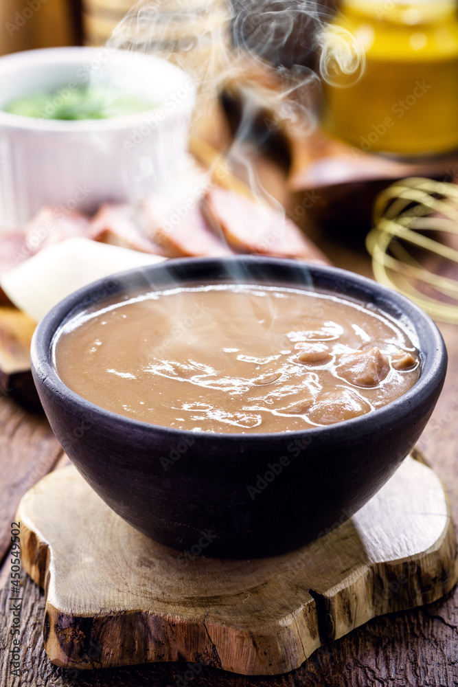 Brazilian bean broth, homemade bean soup served warm in winter, with ingredients in the background Brazilian bean broth, homemade bean soup served warm in winter, with ingredients in the background