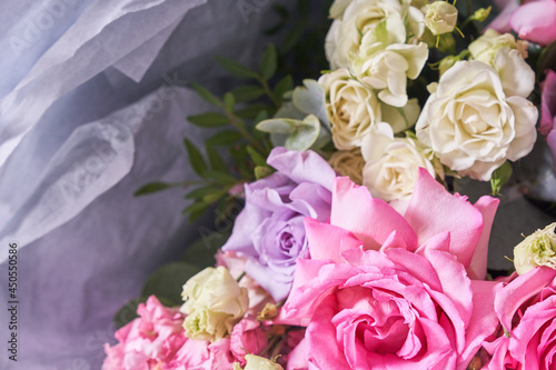 Part of a large bouquet of flowers in close-up. Large pink roses. On a light background  top view. Horizontal composition. High quality photo