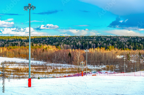 Stunning view of the forest from the ski resort. Travel on vacation.Ski slope, steep descent in spring on a bright sunny day. Natural background. photo