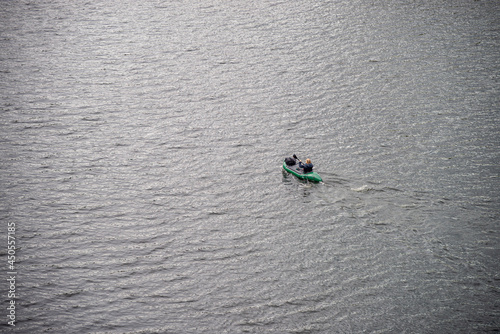Mann cruising in a canoe on a natural lake. A man in a green kayak between.