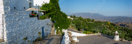 panorama of a viewpoint of the town of Mairena in which you can see the roofs and chimneys of houses and the Alpujarra landscape with other towns and mountains with vegetation photo