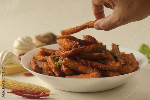 Crisp fried baby corn or Baby corn fritters prepared by deep frying steamed baby corn dipped in a spicy flour batter. photo