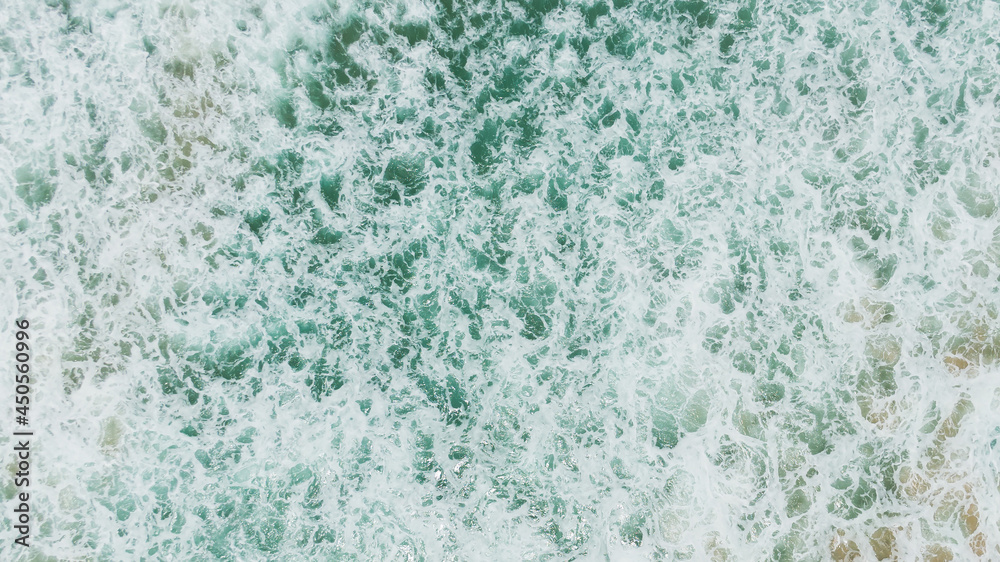 Fototapeta premium Top view or aerial view of Beautiful crystal clear water and white beach.Beautiful Landscape views famous beach waves and sea background. 