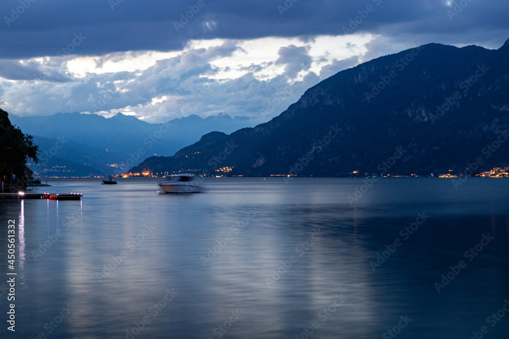 Night view of Lake Como and the cloudy mountains of Vasenna