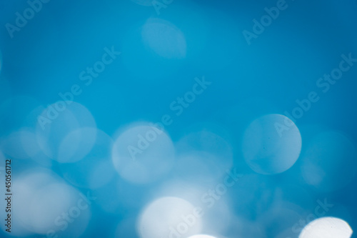 Soft focus bokeh light effects over a rippled,Lights on sea waves background.