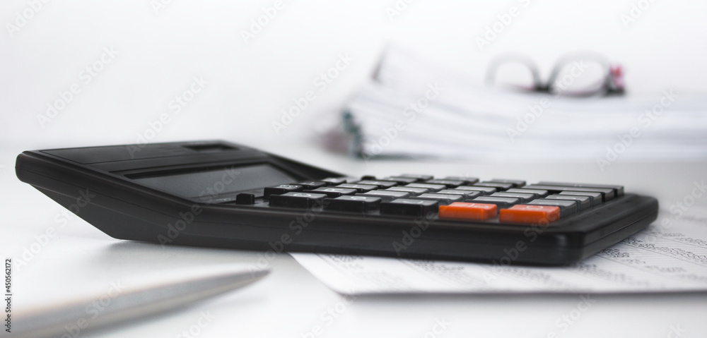 Stack of documents , calculator, pen placed on a business desk in a business office. Copy space Stack of documents , calculator, pen placed on a business desk in a business office. Copy space