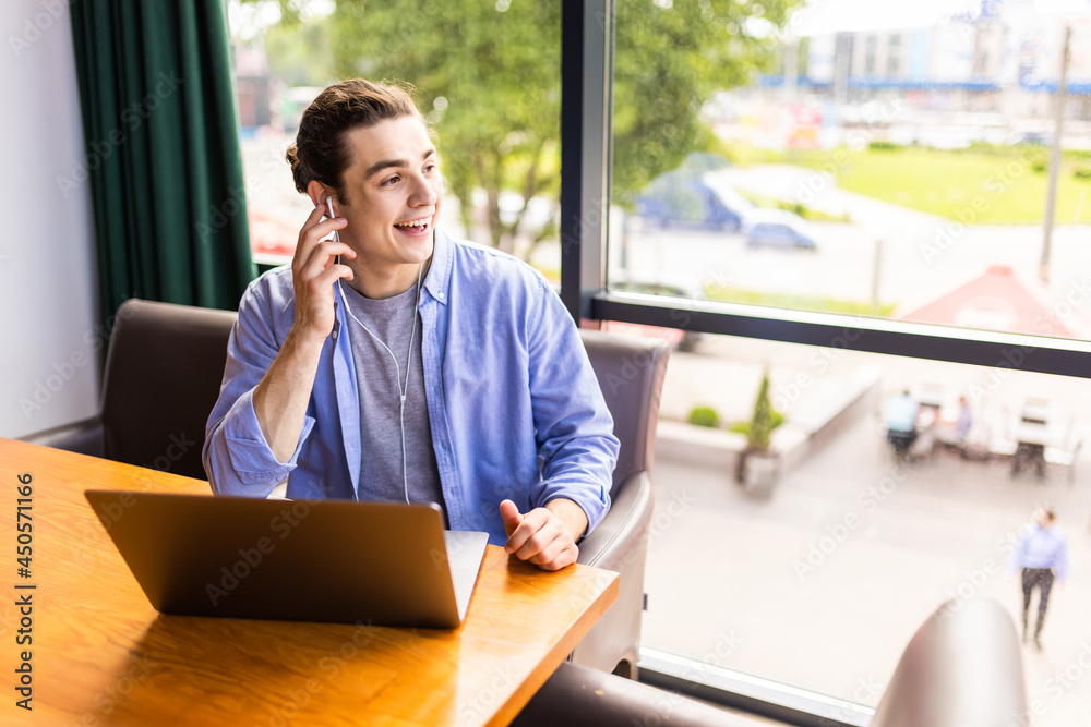 Successful male entrepreneur in digital headphones during productive freelance work at modern laptop computer connected to high speed wireless internet Successful male entrepreneur in digital headphones during productive freelance work at modern laptop computer connected to high speed wireless internet