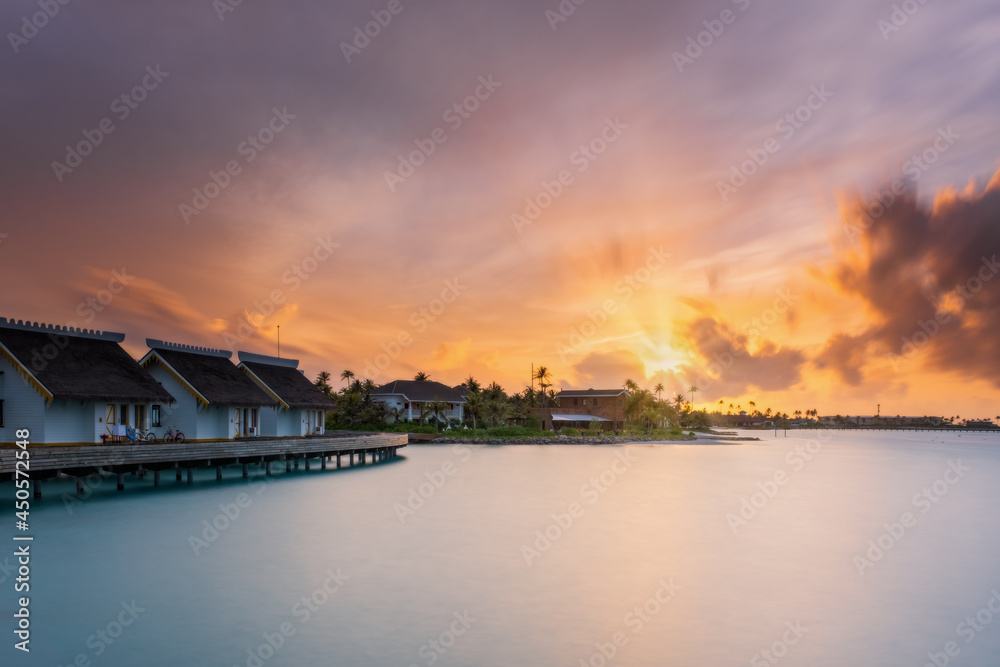 Sunset over sand island beach in Maldives. Crossroads Maldives, saii lagoon hotel. Long exposure picture taken in july 2021 Sunset over sand island beach in Maldives. Crossroads Maldives, saii lagoon hotel. Long exposure picture taken in july 2021