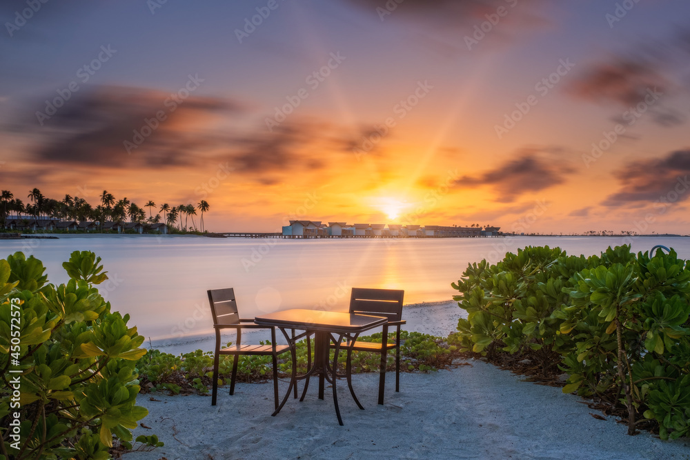 Outdoor restaurant with views of ocean and beautiful sky at sunrise. Crossroads Maldives, saii lagoon. Long exposure picture. July 2021