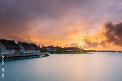 Sunset over sand island beach in Maldives. Crossroads Maldives, saii lagoon hotel. Long exposure picture taken in july 2021