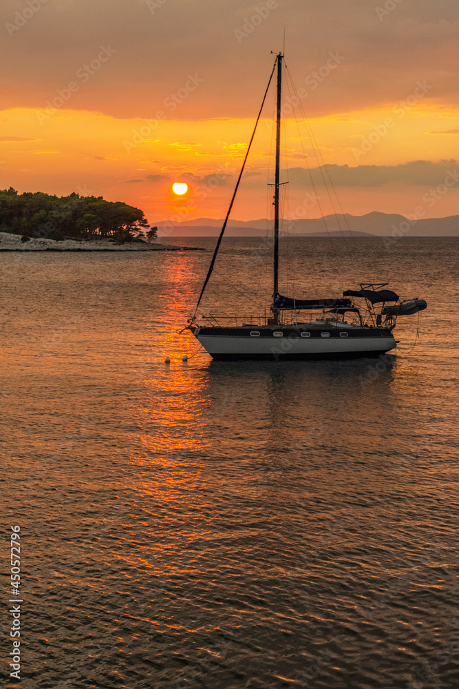 Dramatic rainy clouds during sunset over bay in Splitska on Brac island in Croatia.