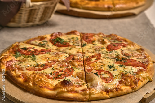 Ruddy pizza with red tomatoes on a wooden tray