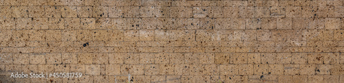 Fotografie, Obraz Wall made with many tuff bricks. Wall of tuff stone.