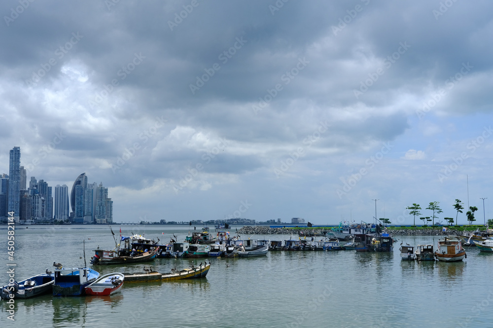 Small fishing boats in the seafood market of Panama with the skyline in the background